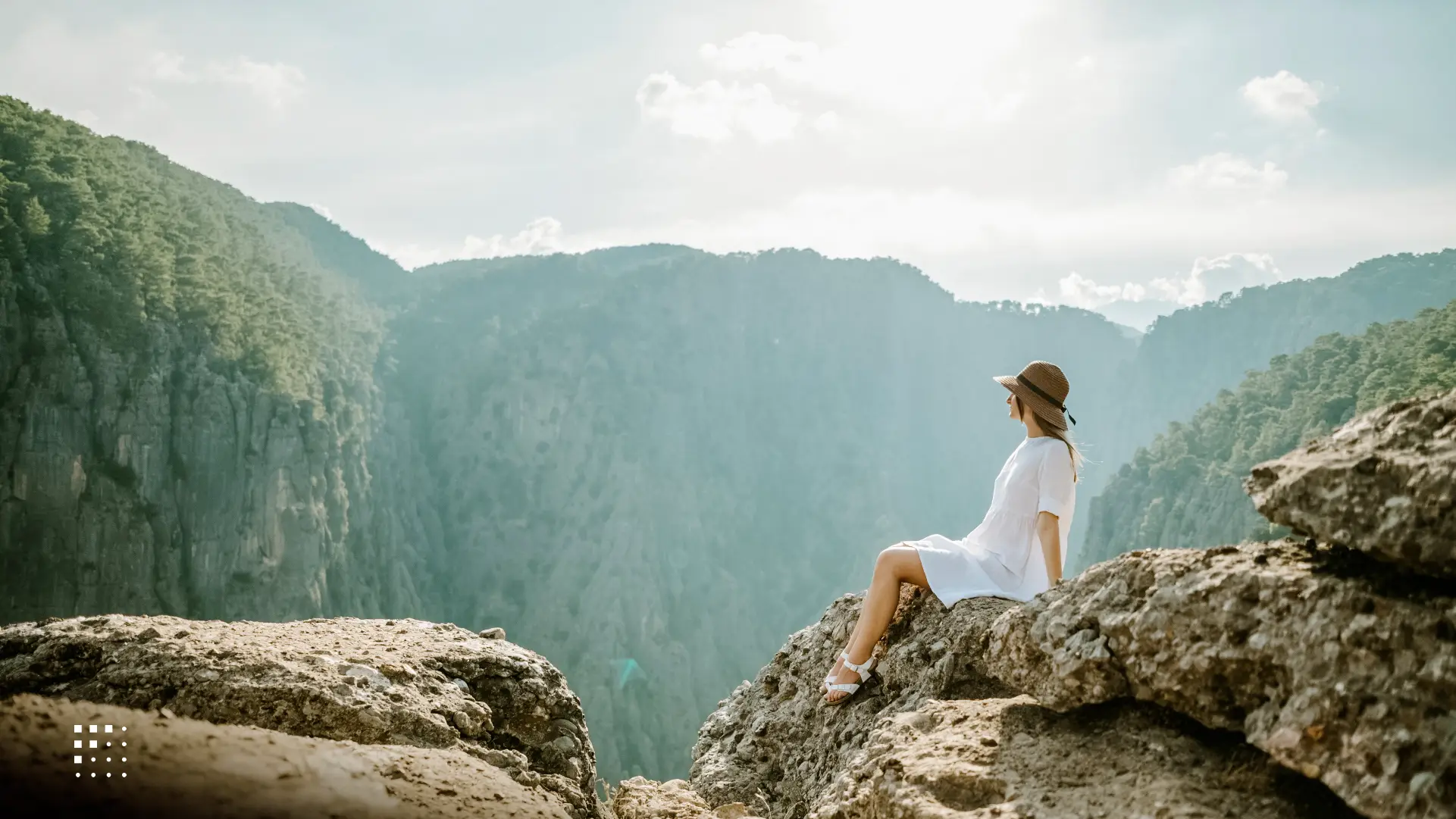An influencer digital nomad basking in the sun on a cliff.